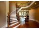 Grand foyer showcasing a curved wooden staircase, hardwood floors, elegant millwork, and bright natural light at 3299 Carmichael Pl, Duluth, GA 30097