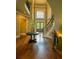 Stunning foyer features wood floors, a curved staircase, a flower arrangement, and a large front door and window at 3299 Carmichael Pl, Duluth, GA 30097