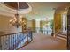 Elegant landing showcases a stunning chandelier and curved staircase with wrought iron railings at 3299 Carmichael Pl, Duluth, GA 30097