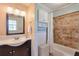 Bright bathroom featuring a dark vanity and tiled shower-tub, offering a blend of functionality and style at 3868 Sharon Dr, Powder Springs, GA 30127