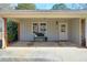 Inviting covered entryway with gray-painted siding, bench seating, and brick pillars at 3868 Sharon Dr, Powder Springs, GA 30127