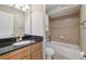 Bathroom featuring granite countertop, wood cabinets, and bathtub with tile surround at 1445 Monroe Ne Dr # 14F, Atlanta, GA 30324