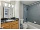 Bathroom with granite countertop vanity, wood cabinets, and bathtub with blue subway tile surround at 1445 Monroe Ne Dr # 14F, Atlanta, GA 30324