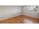Empty bedroom featuring hardwood floors, neutral walls, and window with plantation shutters at 1445 Monroe Ne Dr # 14F, Atlanta, GA 30324
