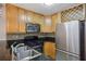 Kitchen featuring granite countertops, stainless steel refrigerator, gas range, and wood cabinetry at 1445 Monroe Ne Dr # 14F, Atlanta, GA 30324