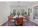 Bright dining room with natural wood table, modern chandelier, and large windows overlooking wooded lot at 2638 Songbird Ln, Grayson, GA 30017