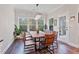Bright dining room with natural wood table, modern chandelier, and large windows overlooking wooded lot at 2638 Songbird Ln, Grayson, GA 30017