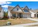Inviting home exterior featuring a covered porch, well-maintained landscaping, and an attached garage at 2638 Songbird Ln, Grayson, GA 30017