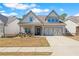 Charming home exterior with manicured lawn, inviting entryway, and attached two-car garage at 2638 Songbird Ln, Grayson, GA 30017