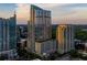 View of high-rise building at sunset featuring a pool deck and sleek, modern design at 855 Peachtree Ne St # 1906, Atlanta, GA 30308