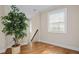 Light filled hallway with hardwood floors and a potted tree at 2011 Braeburn Se Cir, Atlanta, GA 30316