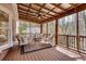 Inviting screened porch with wood floors, ceiling fan, and comfortable seating area overlooking wooded backyard at 2242 Greencrest Ne Dr, Atlanta, GA 30345