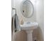 Elegant pedestal sink with oval mirror and stylish fixtures enhances the powder room's charm at 2591 Royston Dr, Duluth, GA 30097
