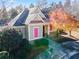 Charming home featuring unique pink shutters, a well-maintained lawn, and colorful autumn foliage at 2591 Royston Dr, Duluth, GA 30097