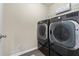 Convenient laundry room with modern washer and dryer units, and storage shelves at 2591 Royston Dr, Duluth, GA 30097