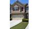 Townhome with neutral siding, red shutters, stone accents, a two-car garage, and green lawn at 3356 Sardis Bend Dr, Buford, GA 30519