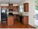 Eat in kitchen with black appliances, granite counters, tile backsplash, hardwood floors, and natural light at 3356 Sardis Bend Dr, Buford, GA 30519
