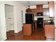 View of kitchen with dark wood cabinets, black appliances, island and hardwood floors at 3356 Sardis Bend Dr, Buford, GA 30519