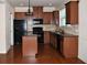 Eat in kitchen with black appliances, granite counters, tile backsplash, hardwood floors, and island at 3356 Sardis Bend Dr, Buford, GA 30519