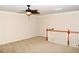 This is a bright living room with neutral carpeting, a ceiling fan, neutral walls, and a charming stairwell at 3356 Sardis Bend Dr, Buford, GA 30519