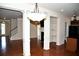 Open-concept living room with hardwood floors, decorative columns, and elegant lighting fixture at 3356 Sardis Bend Dr, Buford, GA 30519