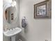 Elegant powder room with a pedestal sink, decorative mirror, and framed art at 1463 Bailey Farm Sw Dr, Marietta, GA 30064