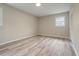 Empty bedroom showcasing light wood flooring, neutral paint, and a window providing natural light at 3355 Lauada Dr, Douglasville, GA 30135