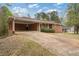 Red brick house with carport, large driveway, and landscaping at 3355 Lauada Dr, Douglasville, GA 30135