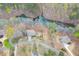 An aerial view shows the house in a wooded area near a lake at 5995 Lanier Heights Cir, Buford, GA 30518