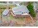 Aerial shot of a home with a large deck, patio, and a detached building nestled among trees and landscaping at 5995 Lanier Heights Cir, Buford, GA 30518