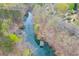 Aerial view showcases a home, a private dock, and serene waterfront living amidst mature trees and a calm lake at 5995 Lanier Heights Cir, Buford, GA 30518