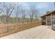 Spacious tiled back deck offering a serene outdoor living space for dining and entertaining with relaxing wooded vista at 5995 Lanier Heights Cir, Buford, GA 30518