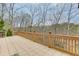 This back deck is ideal for relaxation and outdoor dining, complete with a grill, seating area, and pretty wooded backdrop at 5995 Lanier Heights Cir, Buford, GA 30518
