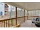 Enjoy outdoor living on this inviting back deck with wooded view, complete with comfortable chairs and a grill at 5995 Lanier Heights Cir, Buford, GA 30518