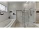 Bathroom featuring a soaking tub, walk-in shower, and neutral tile flooring at 5995 Lanier Heights Cir, Buford, GA 30518