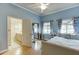Bedroom featuring light blue walls, hardwood floors, and an ensuite bathroom at 5995 Lanier Heights Cir, Buford, GA 30518