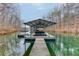 Still lake view of a boat in covered dock, trees in background at 5995 Lanier Heights Cir, Buford, GA 30518
