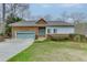 Charming home with a stone and siding exterior, a well-manicured lawn, and an attached two-car garage at 5995 Lanier Heights Cir, Buford, GA 30518