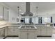 Modern kitchen with gas cooktop, stainless hood, and view of the adjacent living room at 5995 Lanier Heights Cir, Buford, GA 30518
