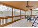 This screened porch is the perfect spot for enjoying the outdoors with dining table and lovely wooded view at 5995 Lanier Heights Cir, Buford, GA 30518