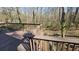An outdoor deck with wooden railings overlooking a green landscape with bare trees at 2172 Nancy Way, Loganville, GA 30052