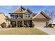 Charming two-story brick home featuring a well-manicured lawn and a welcoming covered front porch at 3475 Summerlin Pkwy, Lithia Springs, GA 30122
