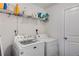 Bright laundry room featuring white appliances and a wire shelf for storage at 3475 Summerlin Pkwy, Lithia Springs, GA 30122