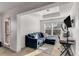 Bright living room featuring a blue sectional sofa, a desk with ring light, and large windows at 3475 Summerlin Pkwy, Lithia Springs, GA 30122