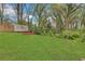 Backyard with lush green grass, mature trees, and a storage shed at the rear of the property at 1944 Lakewood Se Ter, Atlanta, GA 30315