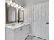 Bathroom featuring a double sink vanity with wooden framed mirrors and modern lighting fixtures above at 1944 Lakewood Se Ter, Atlanta, GA 30315