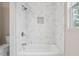Bathroom tub and shower with elegant white marble-style tile at 1944 Lakewood Se Ter, Atlanta, GA 30315
