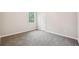 Carpeted bedroom with a window and a door showing the empty space of the room at 1944 Lakewood Se Ter, Atlanta, GA 30315