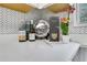 Stylish kitchen counter featuring marble surface, herringbone backsplash, decorative plate, orchid, and bottled beverages at 1944 Lakewood Se Ter, Atlanta, GA 30315