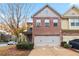 Charming two-story townhome with a brick facade and a two-car garage at 3879 Brockenhurst Dr, Buford, GA 30519
